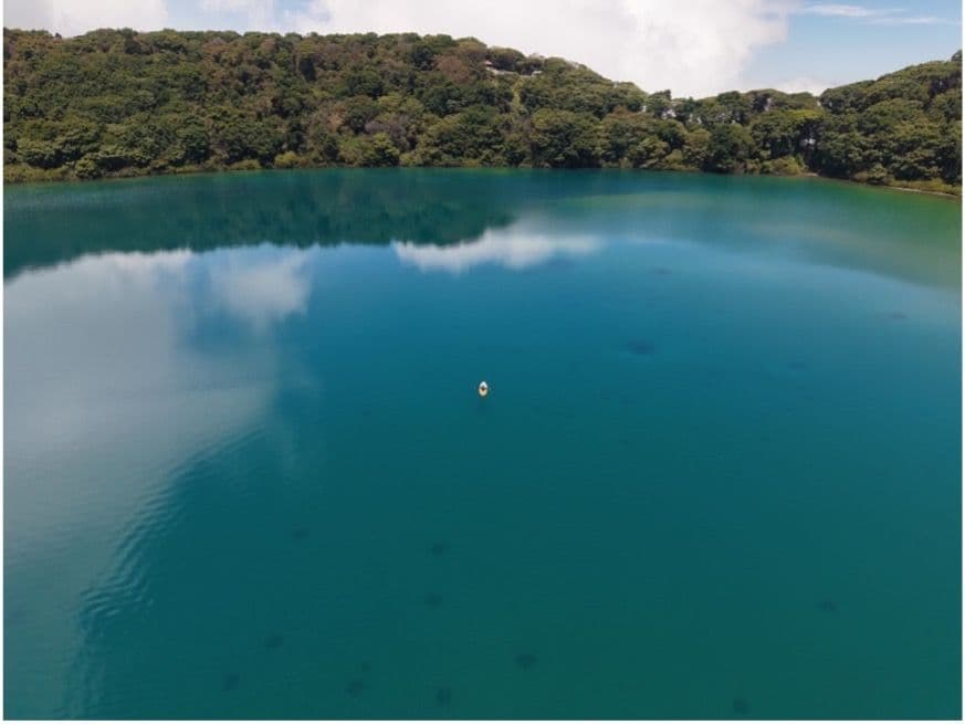 Drone shot of Lago Botos showing a kayak (center) performing water sampling.