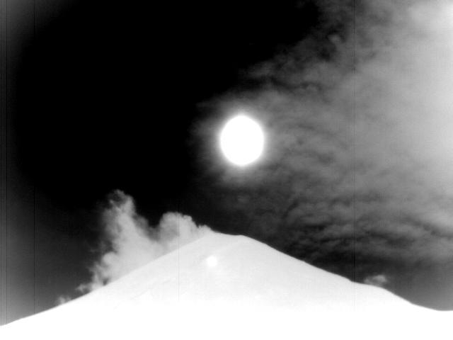 An example view of the summit of Cleveland in the infrared spectrum from the CLNE site. The silhouette of Cleveland is present in the foreground, with the plume visible against a dark sky.