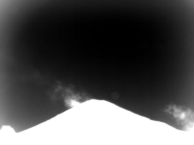 An example view of the summit of Cleveland in the infrared spectrum from the CLNE site. The silhouette of Cleveland is present in the foreground, with the plume visible against a dark sky.