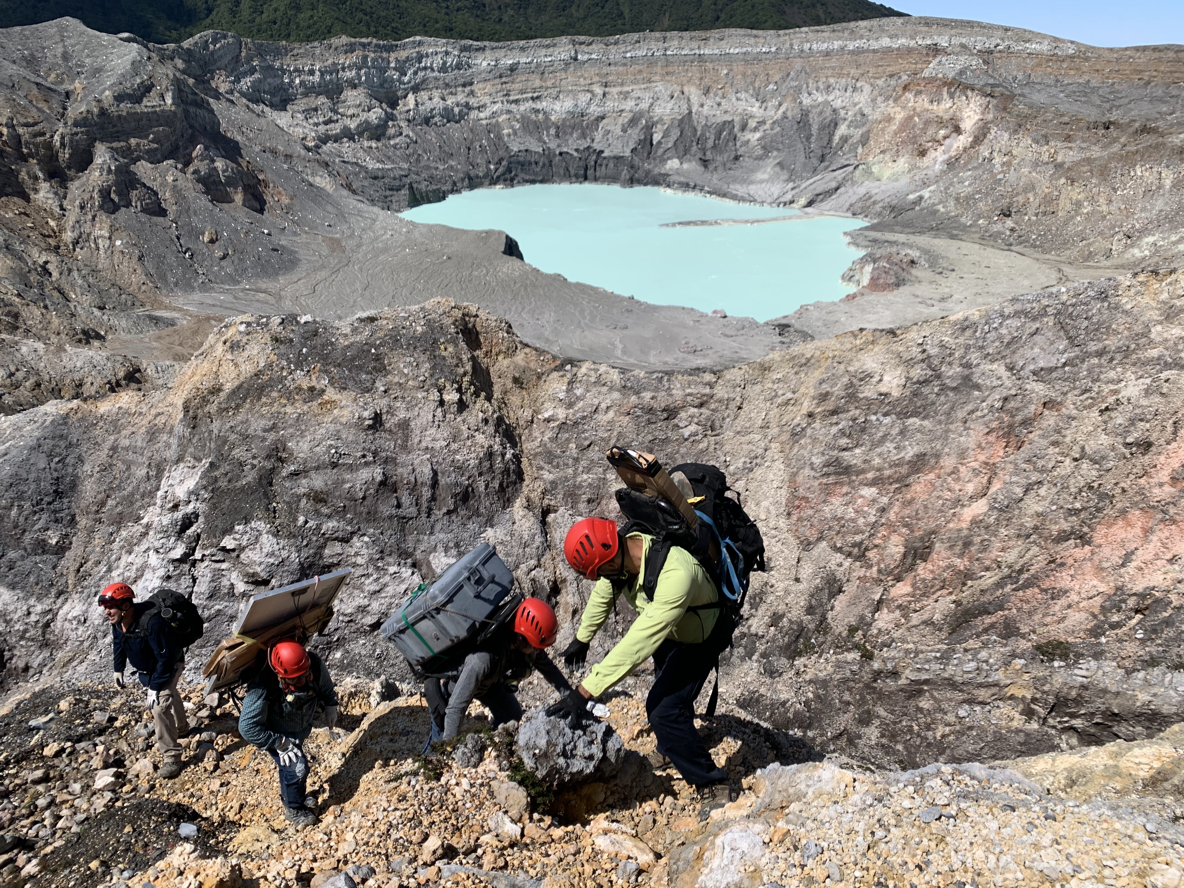 Researchers working in the crater region are seen carrying equipment for a scientific instrument deployment. Credit: OVSICORI.