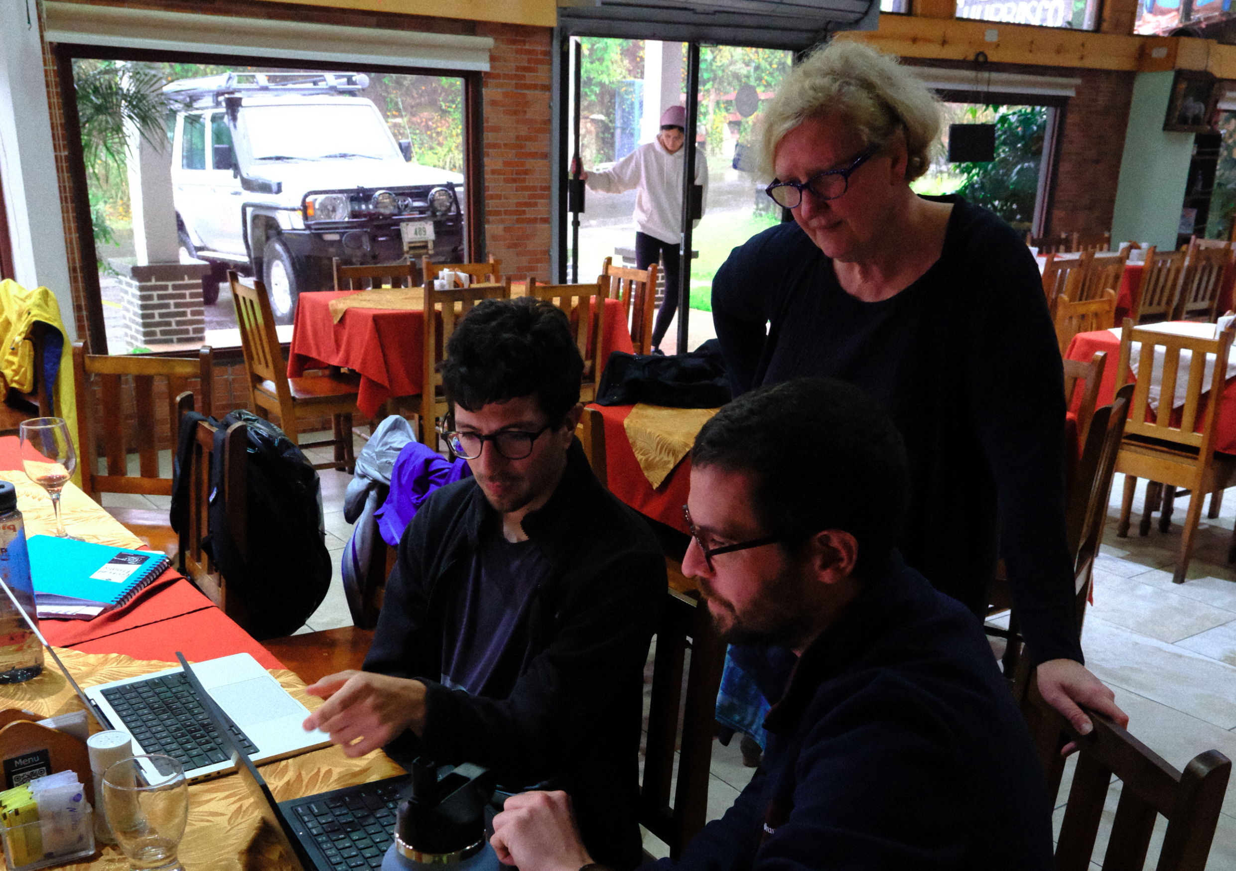 Leo van der Laat (sitting, left, OVSICORI), Terry Plank (standing, LDEO), and Corentin Caudron (sitting, right, ULB) review time series data from Poás at El Churrasco while field activities are rained out.